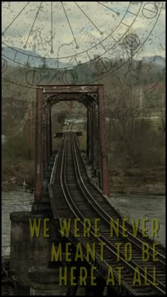 a train track going across a bridge with the words we were never meant to be here at all times