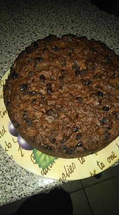 a chocolate cake sitting on top of a yellow and white plate next to a counter