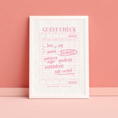 a white framed poster with the words guest check written in pink ink against a peach wall