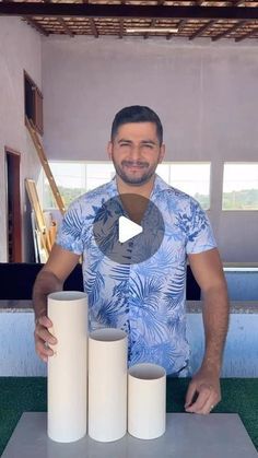 a man standing next to three rolls of paper