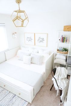 a bedroom with a white bed and two pictures on the wall