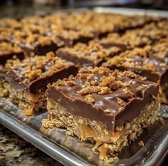 chocolate and granola bars are on a tray with one slice missing from the bar