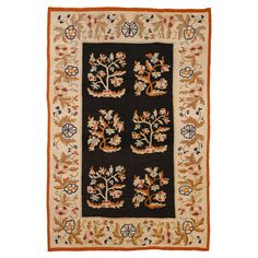 an antique rug with flowers and leaves on black, beige and orange colors is shown