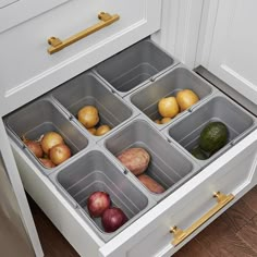 an organized drawer in the kitchen with potatoes, apples and cucumbers on it