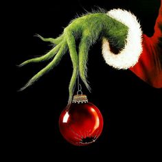 the grinch hanging from a christmas ornament with his hand on it's head