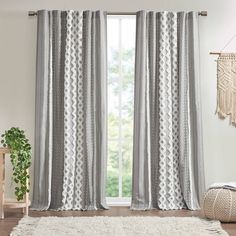 a living room with a white rug and gray curtains on the window sill, next to a potted plant