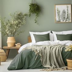 a bedroom with green walls and white bedding, plants on the wall above it