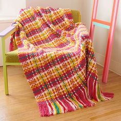 a colorful blanket sitting on top of a wooden chair