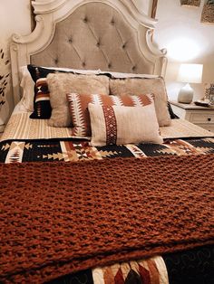 a large bed with pillows and blankets on it's headboard in a bedroom