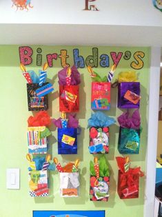 the birthday display is decorated with colorful paper bags and streamers on it's wall