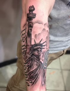 a man's arm with a statue of liberty tattoo on it