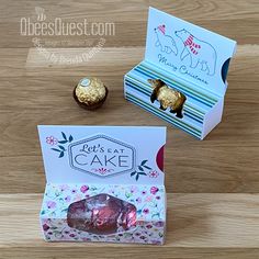 two small boxes with chocolates in them sitting on a wooden table next to each other