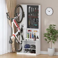 a bike hanging on the wall next to a shelf filled with tools and other items