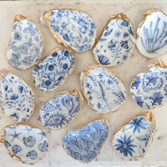 nine blue and white plates sitting on top of a marble slab covered in gold trim