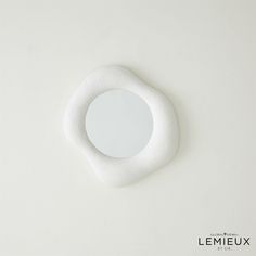 a white circular object on a white surface with the word lemieux written below it