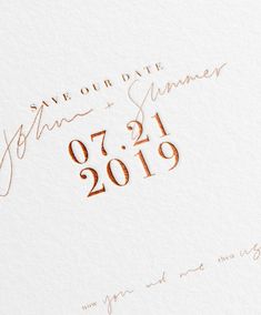 the wedding date is written in copper ink on white paper with an orange and gold foil stamp