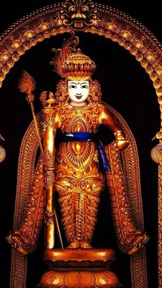 a golden statue with a blue ribbon around it's neck and hands on the chest