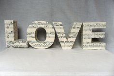 the word love is made out of sheet music and has musical notes on it's sides