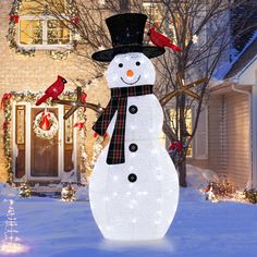 a lighted snowman in front of a house