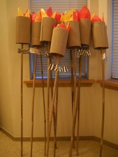 several sticks are lined up in front of a window with some paper wrapped around them