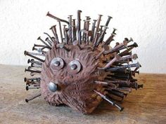 a hedgehog made out of wood with lots of nails sticking out of it's face