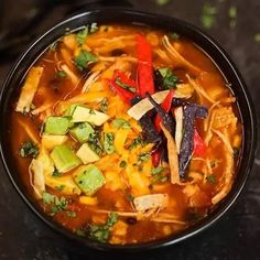 a black bowl filled with soup on top of a table