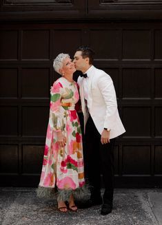 an older couple kissing in front of a garage door