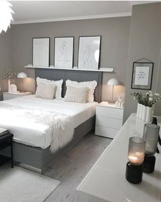 a white and gray bedroom with pictures on the wall