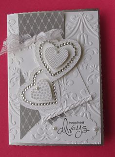 a close up of a greeting card with hearts and ribbons on the front, along with an embellishment