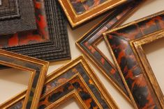 a pile of framed pictures sitting on top of a table