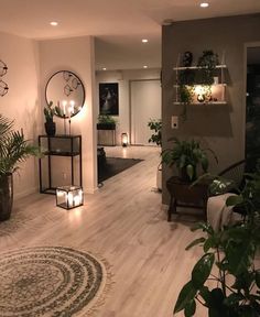 a living room filled with lots of plants and candles on the wall next to it