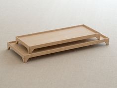 two wooden trays sitting on top of each other in front of a white background