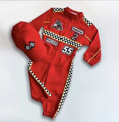 a red racing suit with checkered trims and numbers on the chest, sitting on a white surface