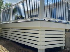 a white deck with railings on the side of it