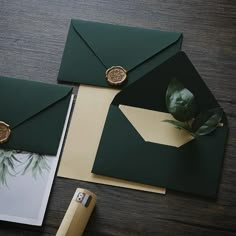 green envelopes with wax stamp on them next to some papers and a piece of paper