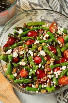 a salad with tomatoes, cucumbers and feta cheese on top is served in a white bowl