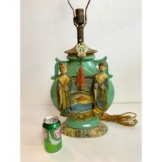 a green lamp sitting on top of a table next to a can