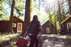 a person walking in the woods carrying a cooler