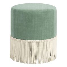 a green and white ottoman with tassels on the bottom, in front of a white background