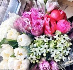 a bouquet of pink and white flowers sitting on top of a table