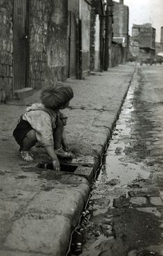 a little boy that is kneeling down in the street