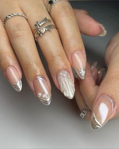 a woman's hands with french manies and rings on their fingers, holding onto her nails