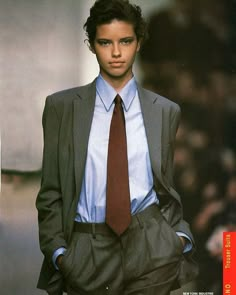 a young man in a suit and tie on the catwalk at a fashion show