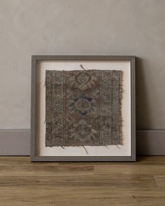 an old rug in a frame on the floor