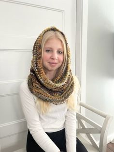 a woman sitting on a chair wearing a scarf