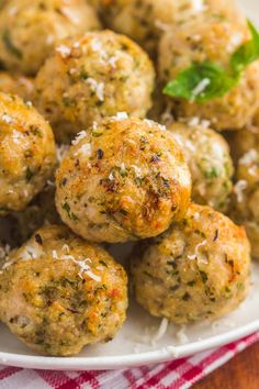 a white plate topped with meatballs covered in parmesan cheese