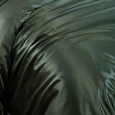 a close up view of a shiny green comforter