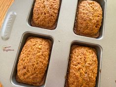 four muffins sitting in a pan on top of a wooden table