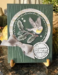 a close up of a card with a bird on it and a ribbon around the edge