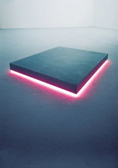 a black square with pink neon lights on it